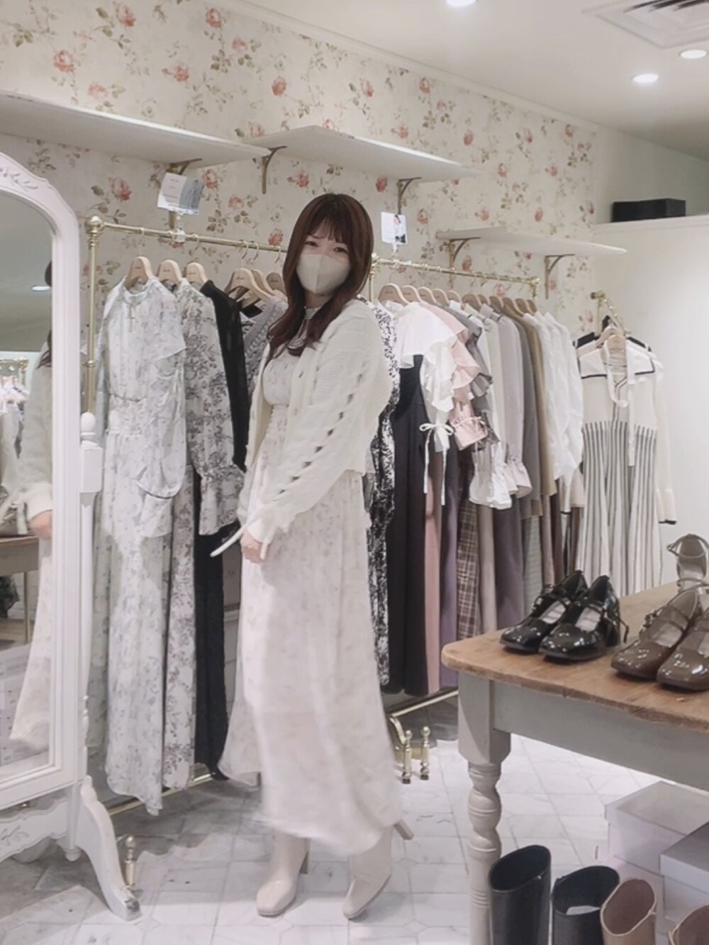 ホワイト系のワンピース、ホワイト系のカーディガン/ボレロ、ホワイト系のブーツを着用したレディースの秋コーディネートの2枚目の写真