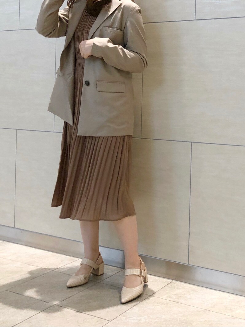 ベージュ系のテーラードジャケット、ベージュ系のワンピース、ホワイト系のパンプスを着用したレディースの春コーディネートの2枚目の写真