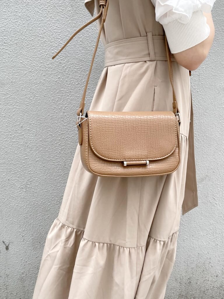 ベージュ系のワンピース、ホワイト系のパンプス、ブラウン系のショルダーバッグを着用したレディースの春コーディネートの8枚目の写真