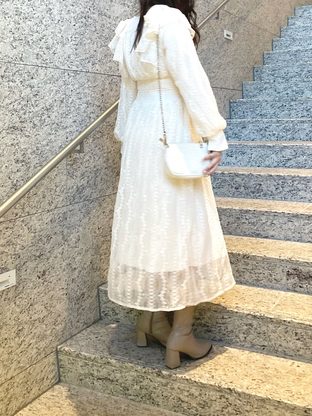 パープル系のその他アウター、ホワイト系のワンピース、ベージュ系のブーツを着用したレディースの冬コーディネートの5枚目の写真