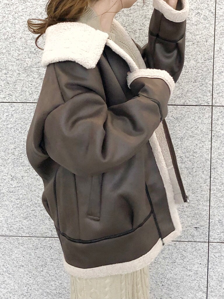 ブラウン系のブーツ、ブラウン系のブルゾン、ベージュ系のワンピースを着用したレディースの冬コーディネートの5枚目の写真