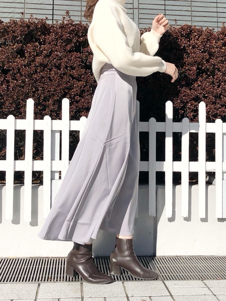 ブラウン系のブーツ、グレー系のスカート、ホワイト系のニット/セーターを着用したレディースの冬コーディネートの3枚目の写真