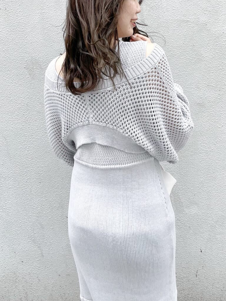 グレー系のワンピース、ホワイト系のハンドバッグ、ホワイト系のパンプスを着用したレディースの秋コーディネートの5枚目の写真