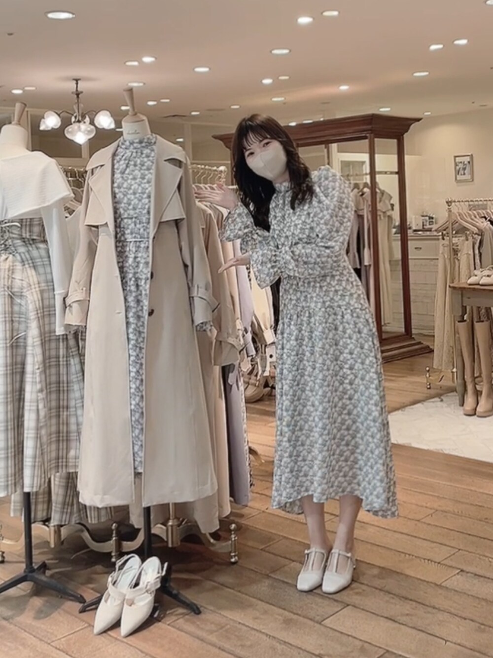 ベージュ系のトレンチコート、ホワイト系のワンピース、ホワイト系のパンプスを着用したレディースの冬コーディネートの2枚目の写真