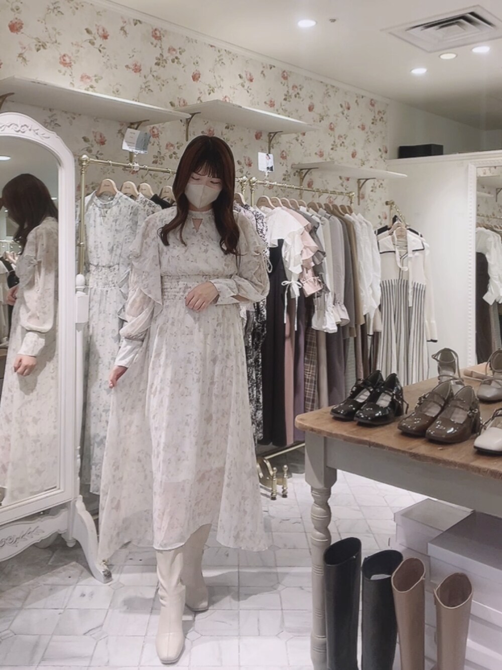 ホワイト系のワンピース、ホワイト系のカーディガン/ボレロ、ホワイト系のブーツを着用したレディースの秋コーディネートの4枚目の写真