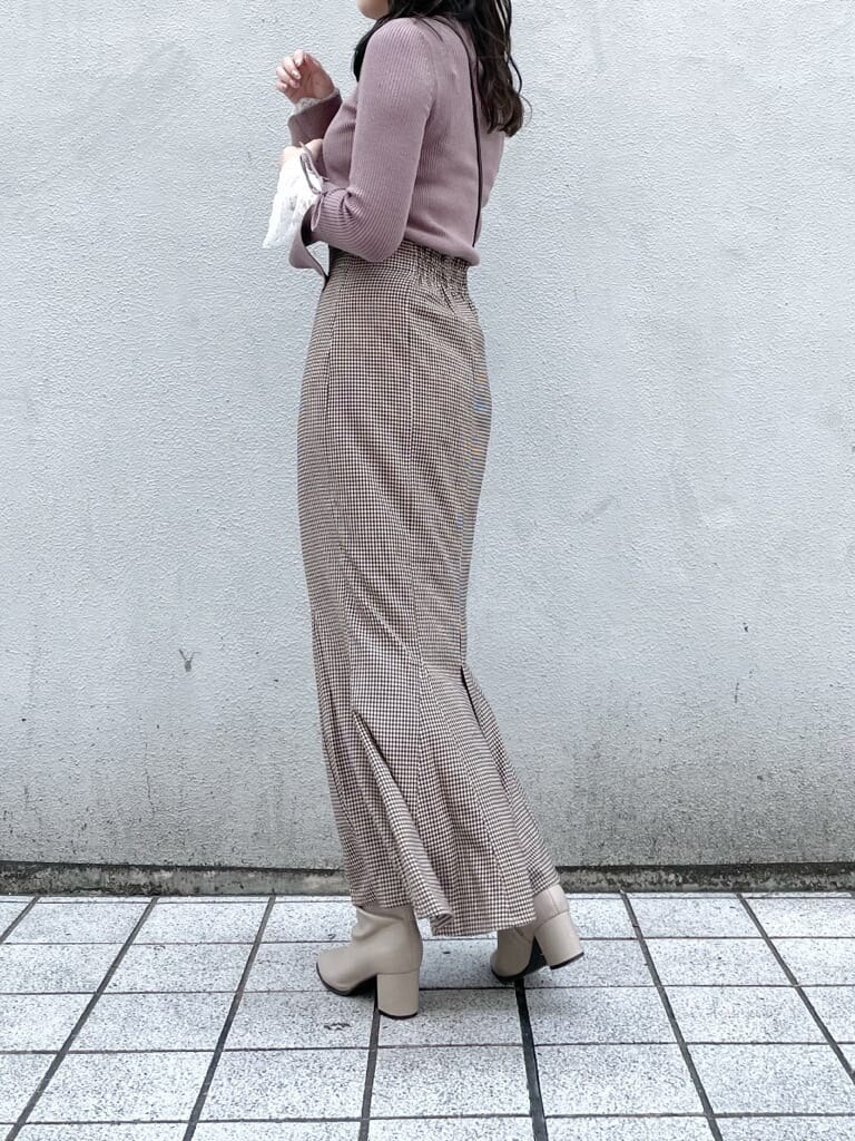 ブラウン系のスカート、ベージュ系のブーツ、ピンク系のニット/セーターを着用したレディースの秋コーディネートの3枚目の写真