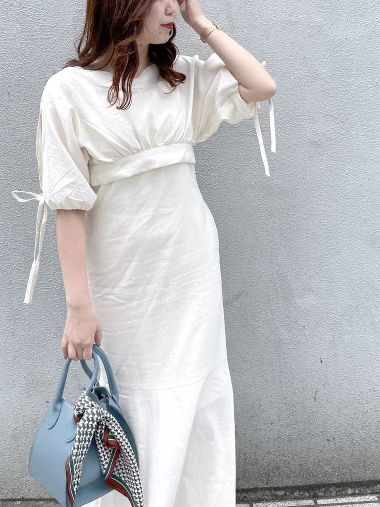 ホワイト系のワンピース、ブルー系のハンドバッグ、ホワイト系のパンプスを着用したレディースの春コーディネートの4枚目の写真