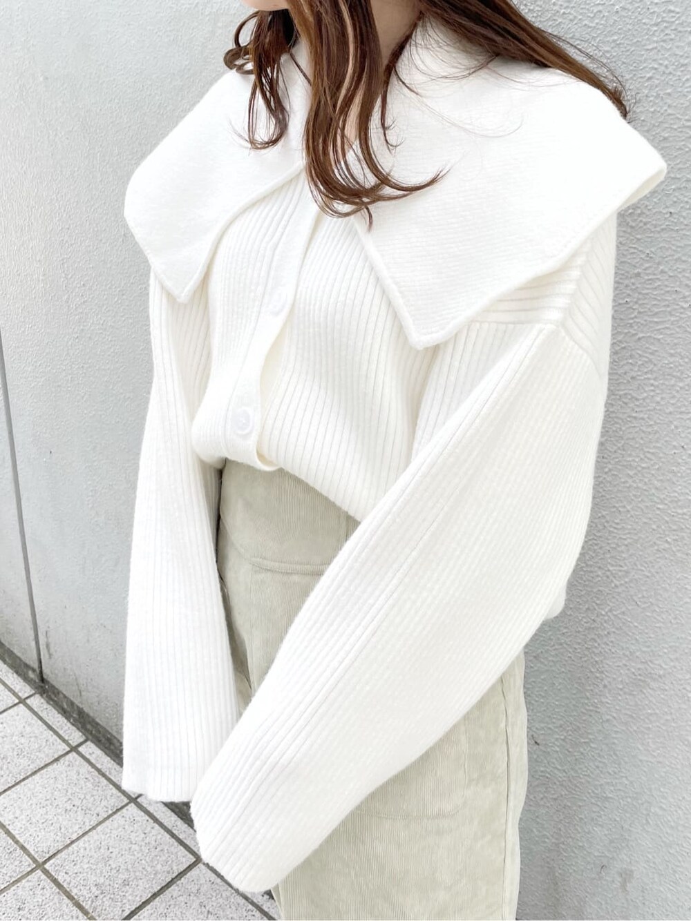 ホワイト系のスニーカー、グリーン系のスカート、ホワイト系のハンドバッグを着用したレディースの秋コーディネートの4枚目の写真