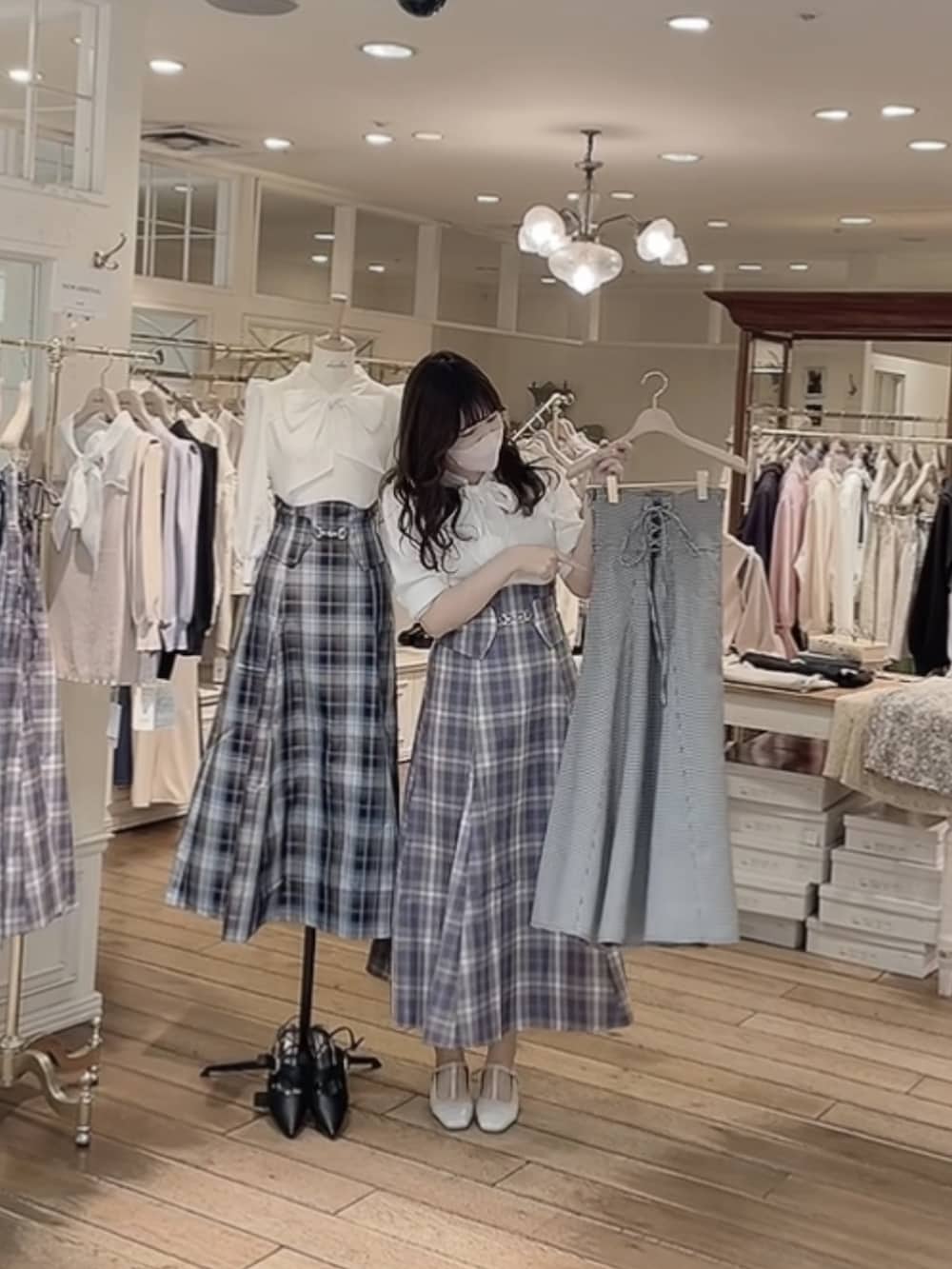 パープル系のスカート、ホワイト系のニット/セーター、ホワイト系のパンプスを着用したレディースの冬コーディネートの3枚目の写真