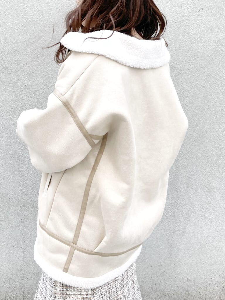 ホワイト系のブルゾン、ベージュ系のブーツ、ベージュ系のニット/セーターを着用したレディースの冬コーディネートの5枚目の写真