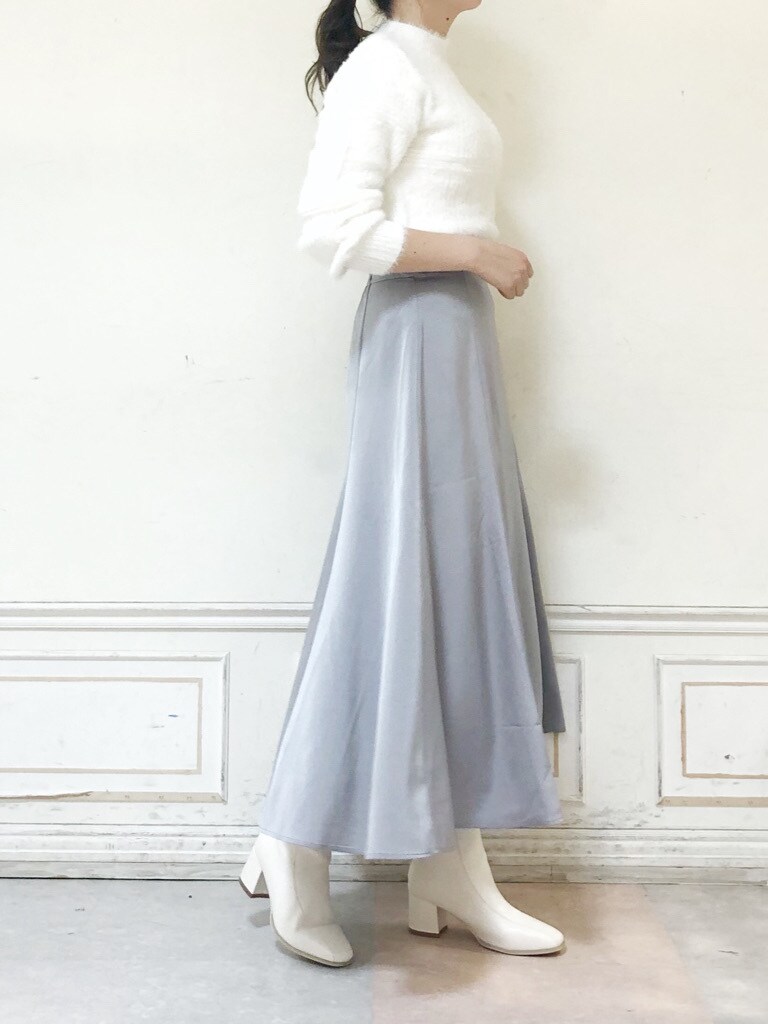 ホワイト系のニット/セーター、ホワイト系のブーツ、グレー系のスカートを着用したレディースの冬コーディネートの6枚目の写真