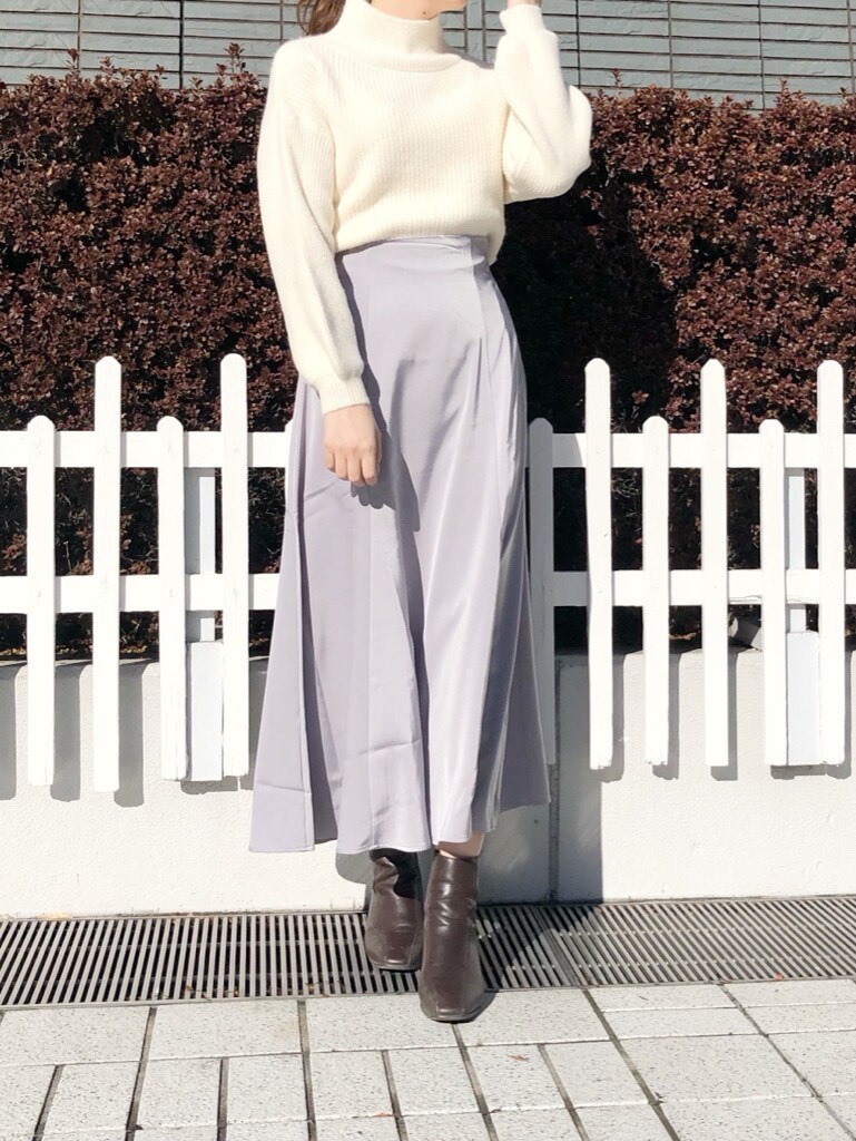 ブラウン系のブーツ、グレー系のスカート、ホワイト系のニット/セーターを着用したレディースの冬コーディネートの2枚目の写真