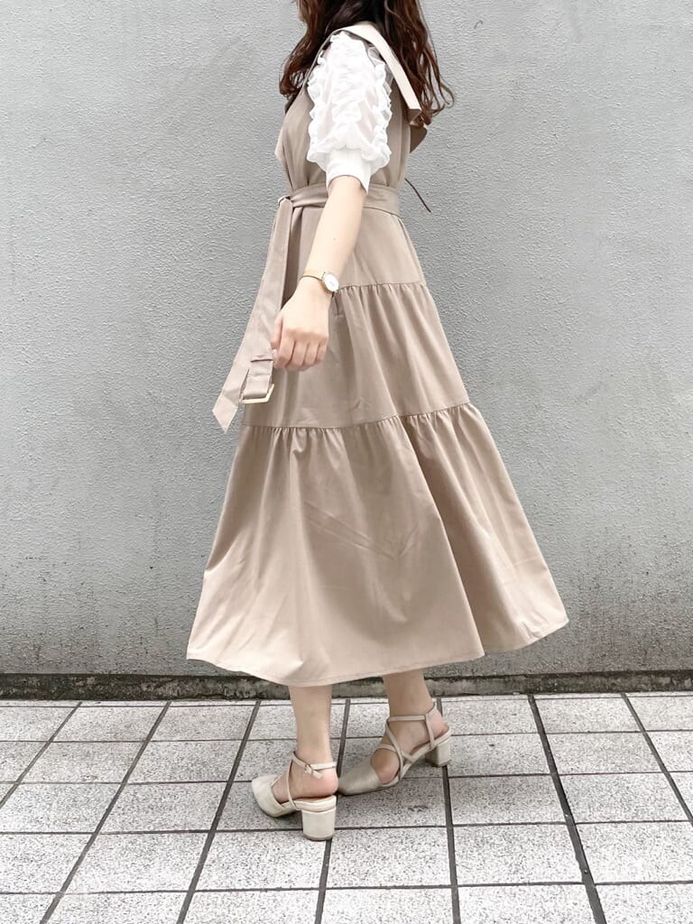 ベージュ系のワンピース、ホワイト系のパンプス、ブラウン系のショルダーバッグを着用したレディースの春コーディネートの3枚目の写真