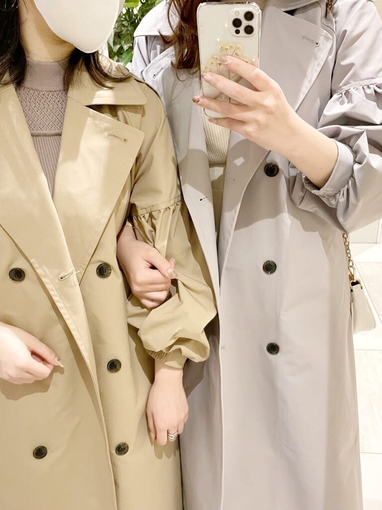 グレー系のトレンチコート、ベージュ系のトレンチコート、ベージュ系のワンピースを着用したレディースの冬コーディネートの2枚目の写真