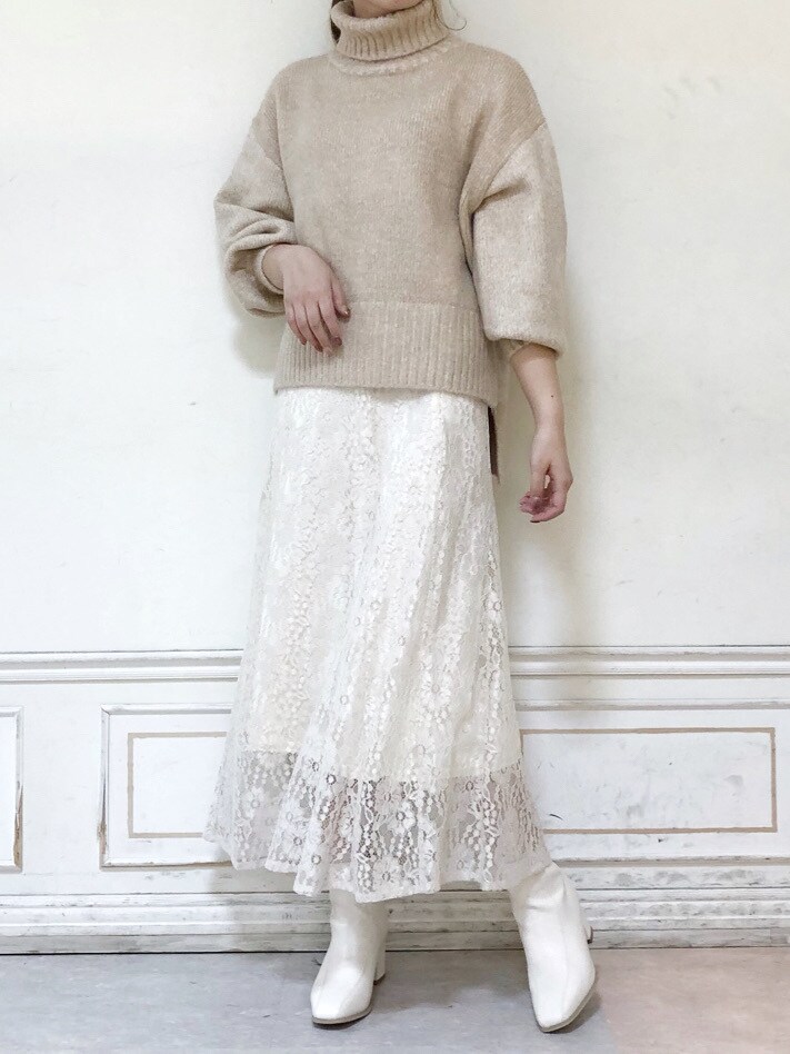ホワイト系のブーツ、ベージュ系のニット/セーター、ホワイト系のスカートを着用したレディースの秋コーディネートの2枚目の写真