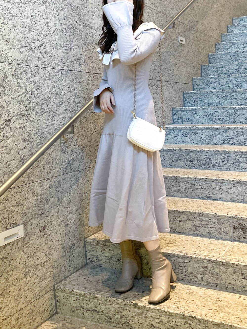 パープル系のワンピース、ホワイト系のその他アウター、ベージュ系のブーツを着用したレディースの冬コーディネートの4枚目の写真