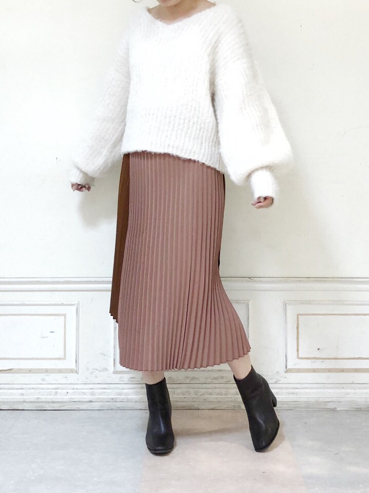 ブラウン系のスカート、ブラウン系のブーツ、ホワイト系のニット/セーターを着用したレディースの秋コーディネートの2枚目の写真
