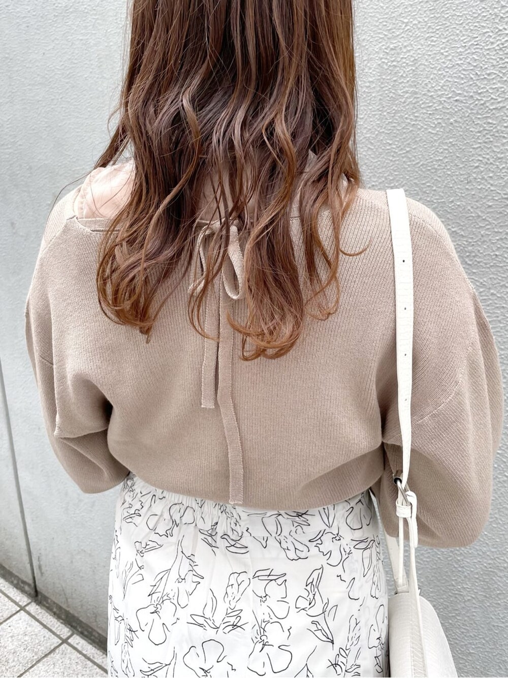 ホワイト系のパンプス、ホワイト系のショルダーバッグ、ホワイト系のスカートを着用したレディースの春コーディネートの7枚目の写真