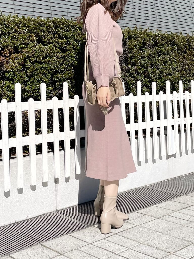 ホワイト系のその他アウター、ベージュ系のハンドバッグ、ベージュ系のブーツを着用したレディースの秋コーディネートの5枚目の写真