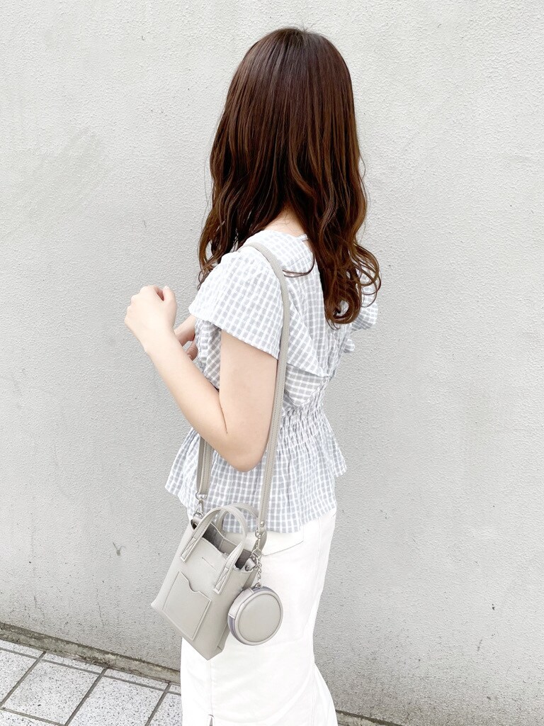 グレー系のハンドバッグ、ブルー系のシャツ/ブラウス、ホワイト系のスカートを着用したレディースの春コーディネートの6枚目の写真