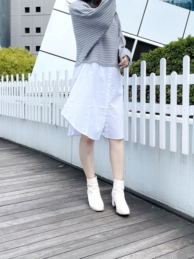 ホワイト系のブーツ、グレー系のニット/セーターを着用したレディースの冬コーディネートの2枚目の写真