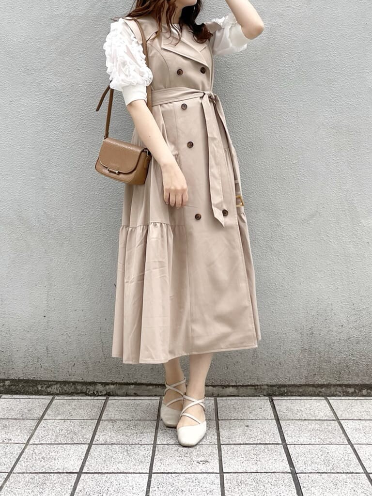 ベージュ系のワンピース、ホワイト系のパンプス、ブラウン系のショルダーバッグを着用したレディースの春コーディネートの2枚目の写真