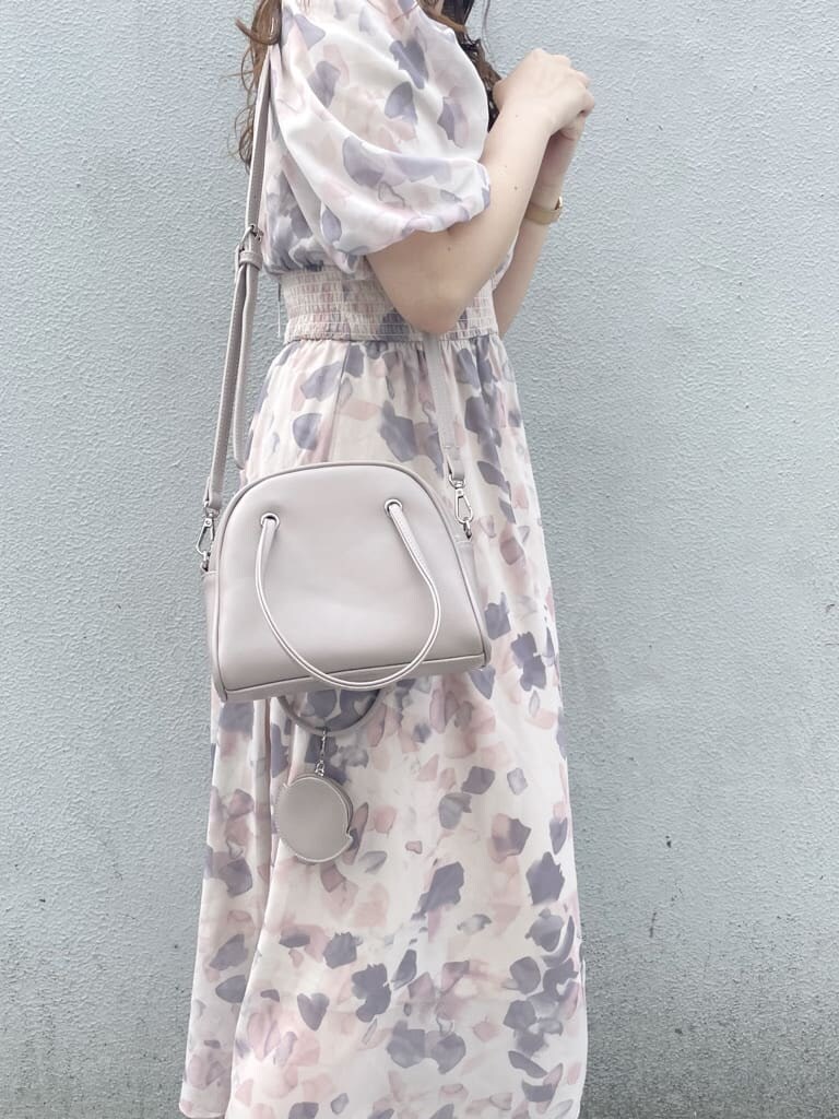 ピンク系のワンピース、ホワイト系のパンプス、ベージュ系のハンドバッグを着用したレディースの春コーディネートの7枚目の写真