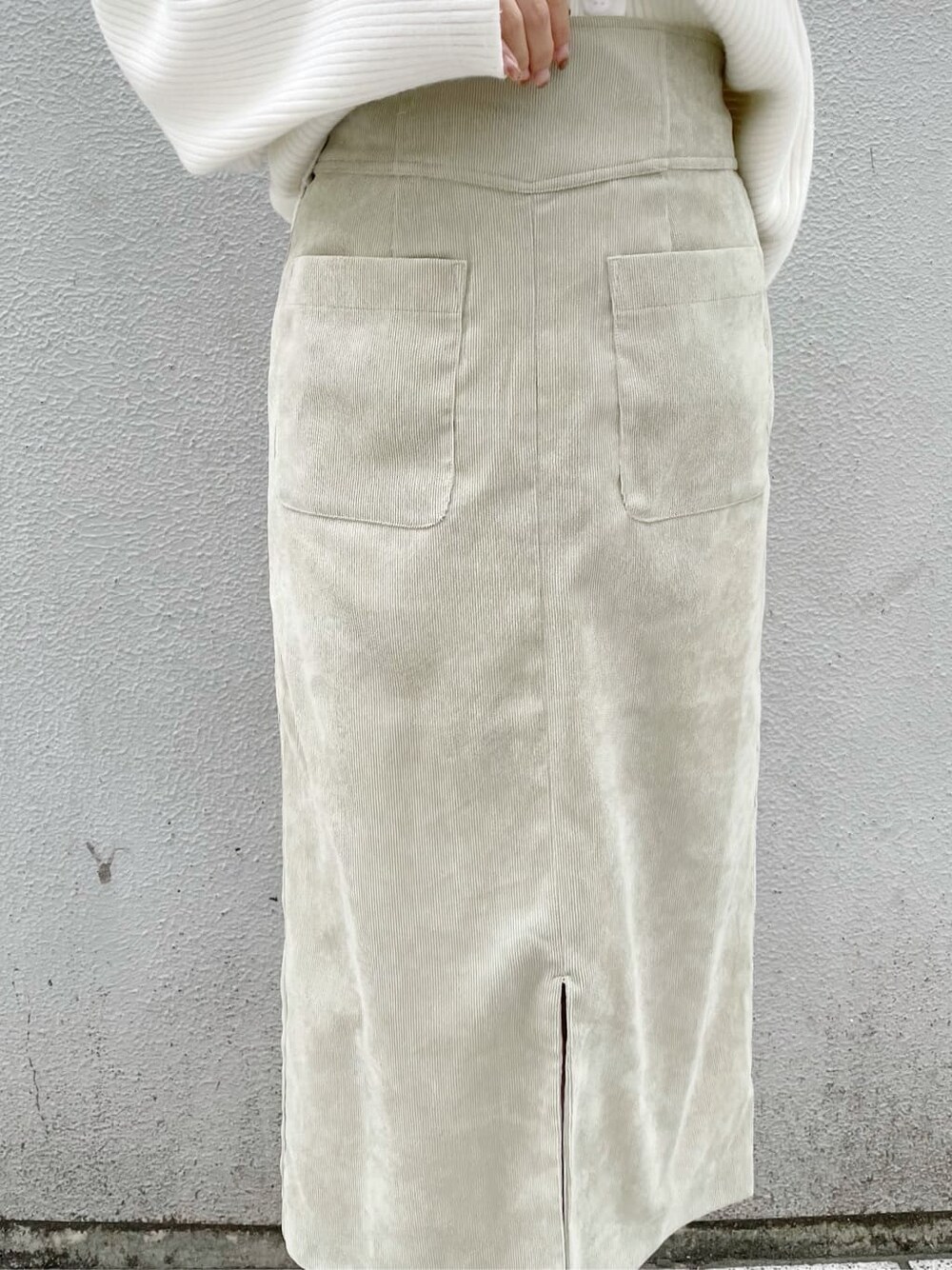 ホワイト系のスニーカー、グリーン系のスカート、ホワイト系のハンドバッグを着用したレディースの秋コーディネートの8枚目の写真