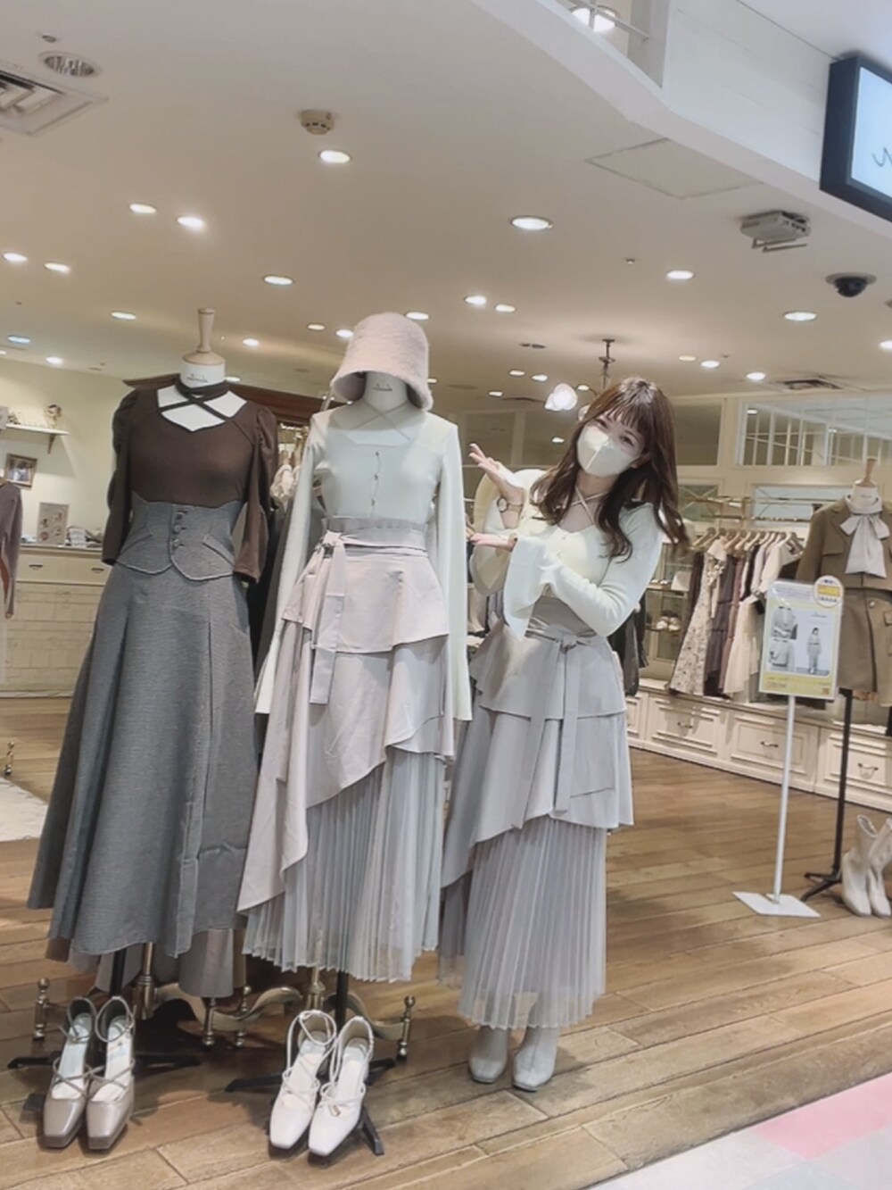 ベージュ系のスカート、ホワイト系のニット/セーター、ホワイト系のブーツを着用したレディースの秋コーディネートの4枚目の写真