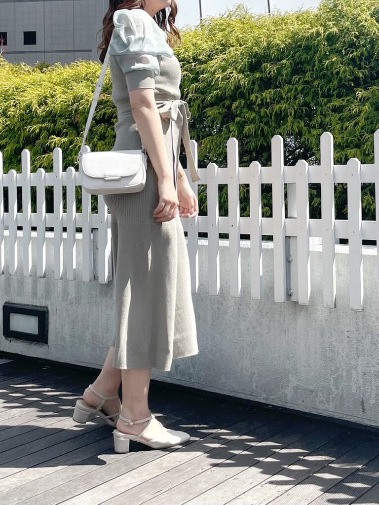ベージュ系のトレンチコート、グリーン系のワンピース、ホワイト系のパンプスを着用したレディースの春コーディネートの7枚目の写真
