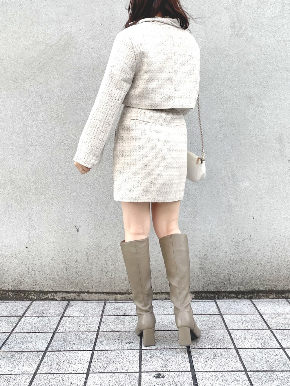 ホワイト系のその他アウター、ホワイト系のスカート、ベージュ系のブーツを着用したレディースの冬コーディネートの2枚目の写真