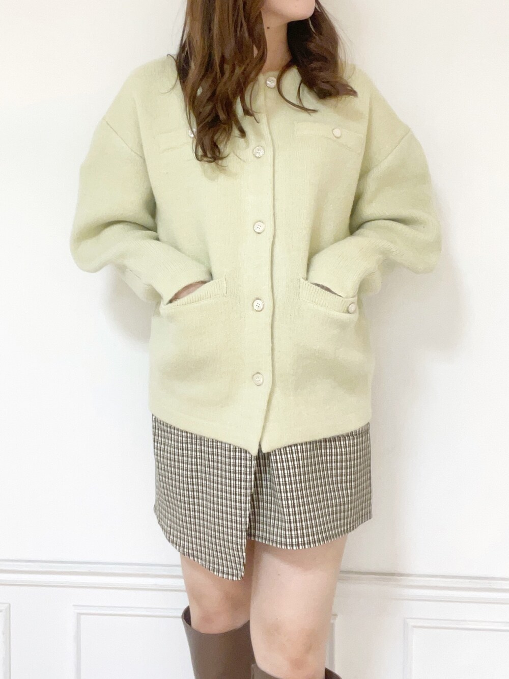 グリーン系のカーディガン/ボレロ、ブラウン系のスカート、ベージュ系のブーツを着用したレディースの秋コーディネートの2枚目の写真