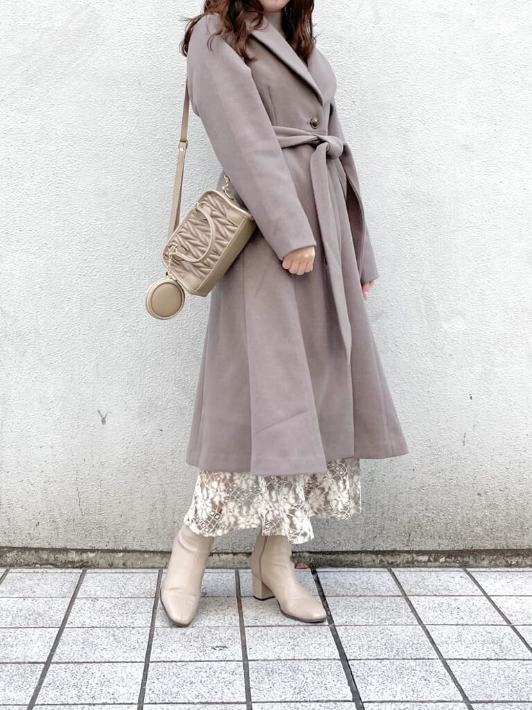 ベージュ系のスカート、ベージュ系のその他アウター、ベージュ系のハンドバッグを着用したレディースの秋コーディネートの5枚目の写真