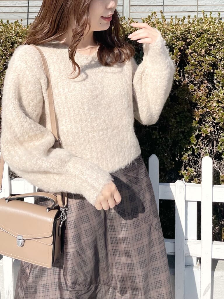 ブラウン系のスカート、ブラウン系のニット/セーター、ベージュ系のブーツを着用したレディースの冬コーディネートの4枚目の写真