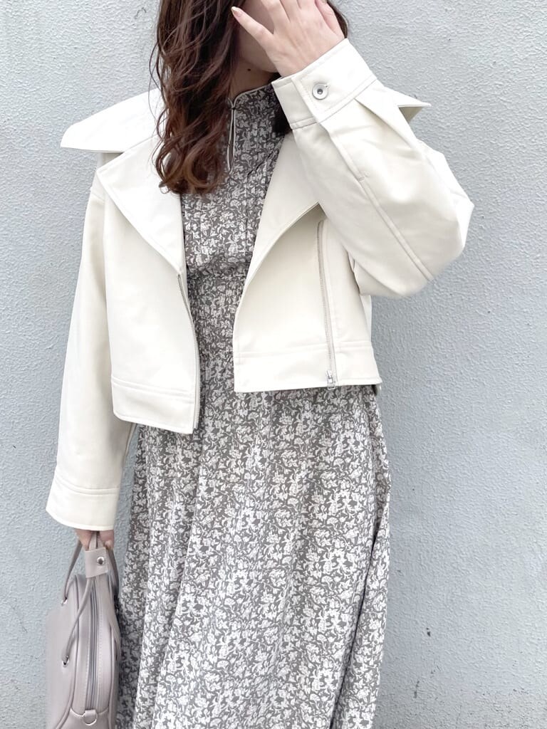 ホワイト系のワンピース、ホワイト系のライダースジャケット、ホワイト系のパンプスを着用したレディースの冬コーディネートの4枚目の写真