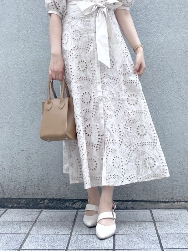 ホワイト系のワンピース、ベージュ系のハンドバッグ、ホワイト系のパンプスを着用したレディースの春コーディネートの10枚目の写真