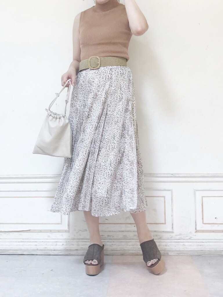 ホワイト系のハンドバッグ、ベージュ系のニット/セーター、ホワイト系のスカートを着用したレディースの夏コーディネートの3枚目の写真