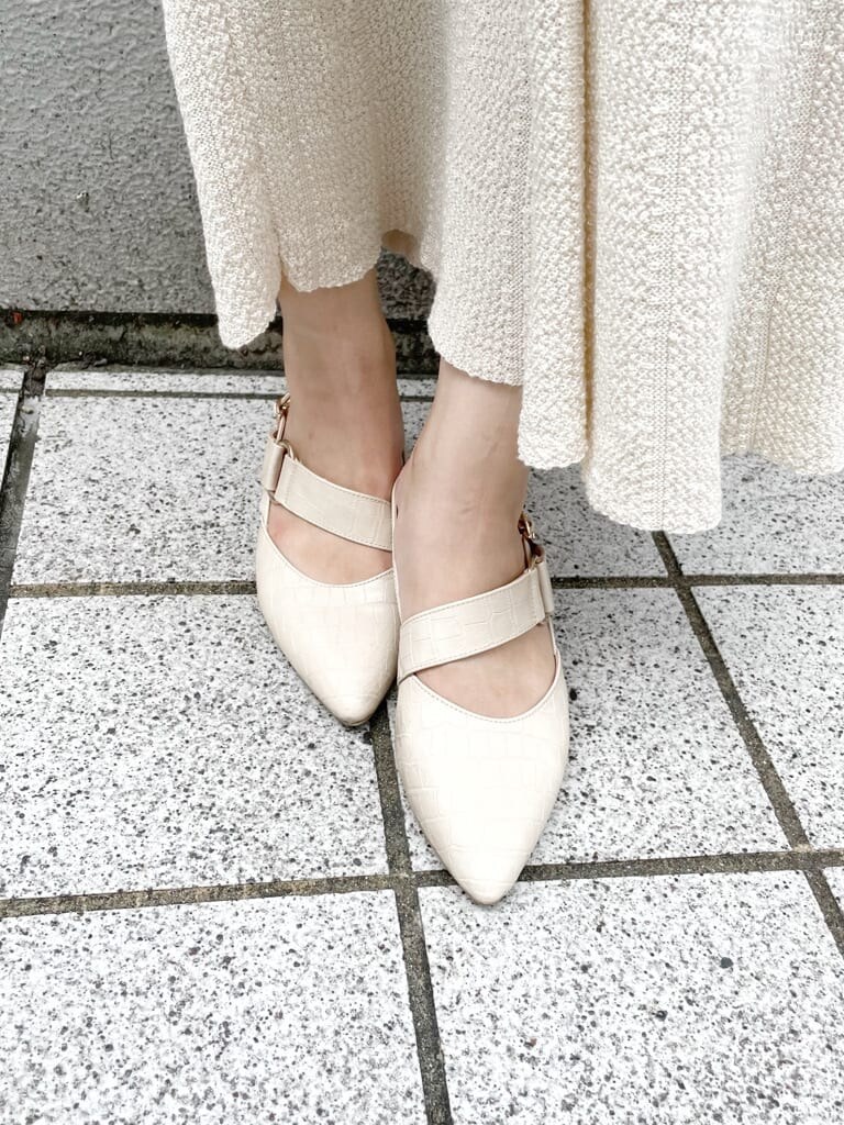 ホワイト系のワンピース、ホワイト系のパンプス、ベージュ系のハンドバッグを着用したレディースの秋コーディネートの6枚目の写真