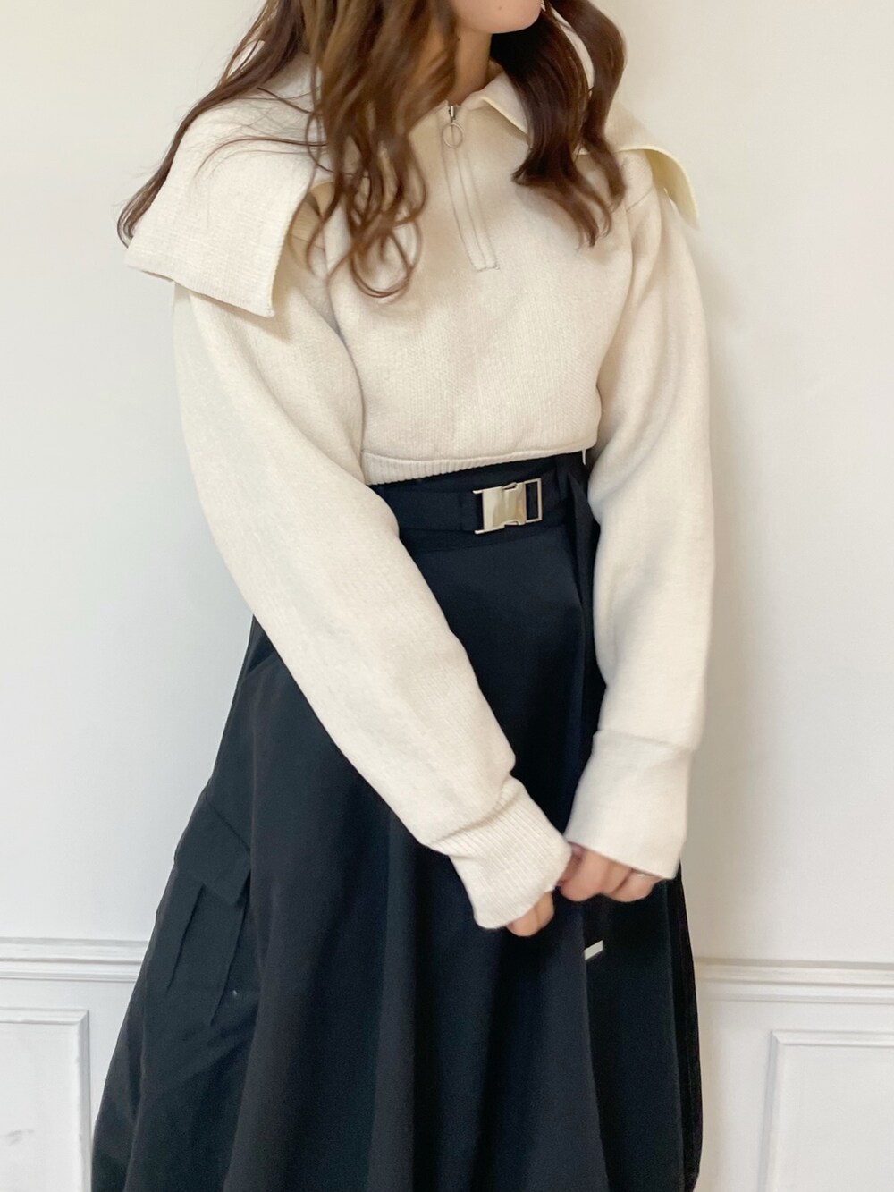 ホワイト系のニット/セーター、ブラック系のスカート、ホワイト系のブーツを着用したレディースの秋コーディネートの4枚目の写真