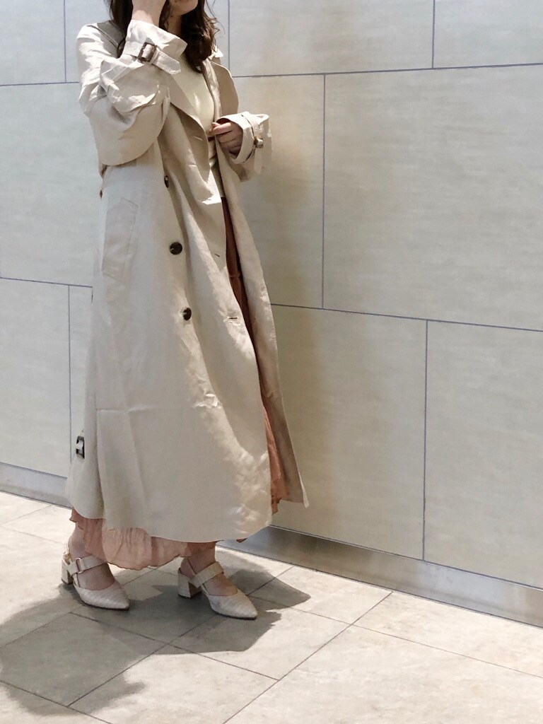 ベージュ系のトレンチコート、ブラウン系のスカート、ホワイト系のパンプスを着用したレディースの春コーディネートの2枚目の写真