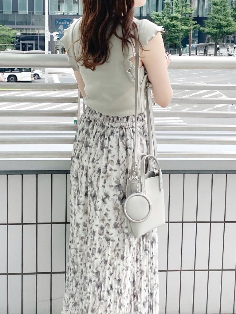 グレー系のハンドバッグ、その他のサンダル、グリーン系のTシャツ/カットソーを着用したレディースの夏コーディネートの3枚目の写真