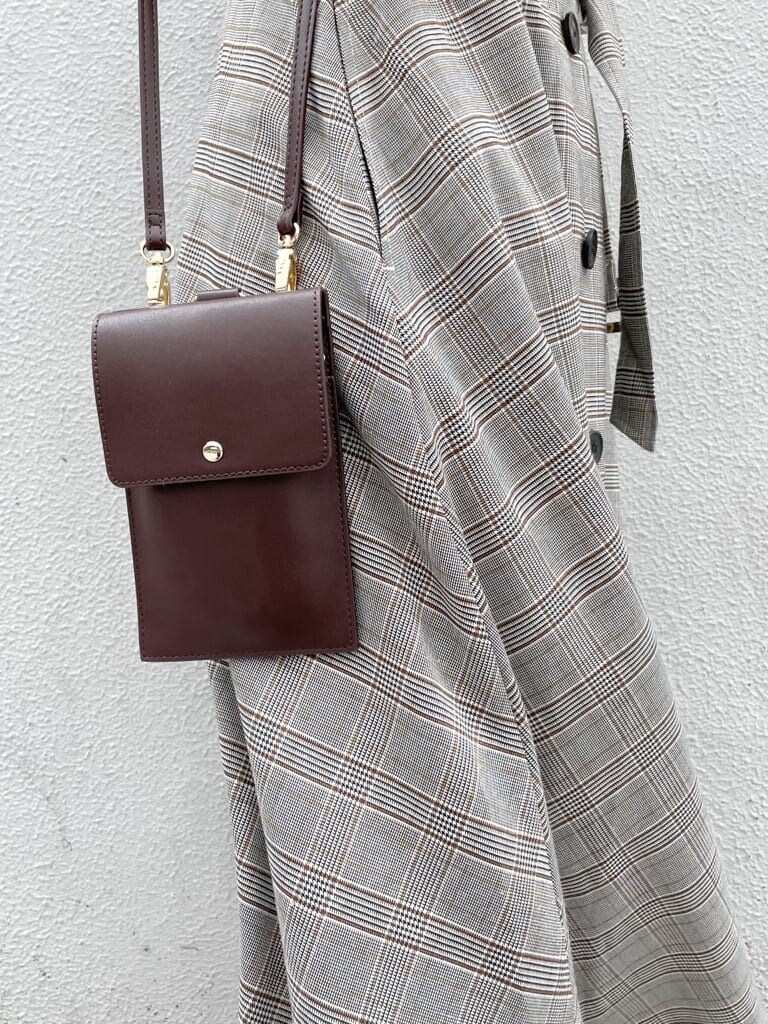 グレー系のワンピース、ホワイト系のニット/セーター、ホワイト系のパンプスを着用したレディースの秋コーディネートの8枚目の写真