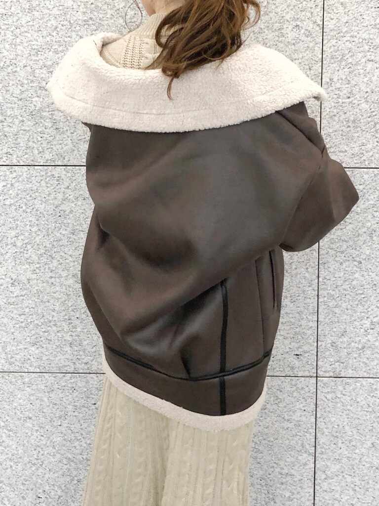 ブラウン系のブーツ、ブラウン系のブルゾン、ベージュ系のワンピースを着用したレディースの冬コーディネートの6枚目の写真