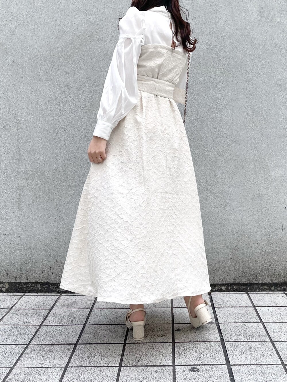 ホワイト系のワンピース、ホワイト系のパンプスを着用したレディースの冬コーディネートの4枚目の写真