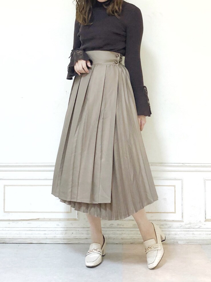 ベージュ系のスカート、ホワイト系のローファー、ブラウン系のニット/セーターを着用したレディースの秋コーディネートの2枚目の写真