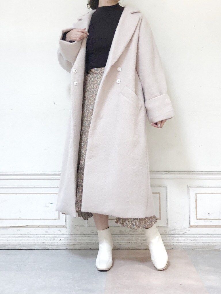ホワイト系のブーツ、ホワイト系のチェスターコート、ホワイト系のスカートを着用したレディースの秋コーディネートの2枚目の写真