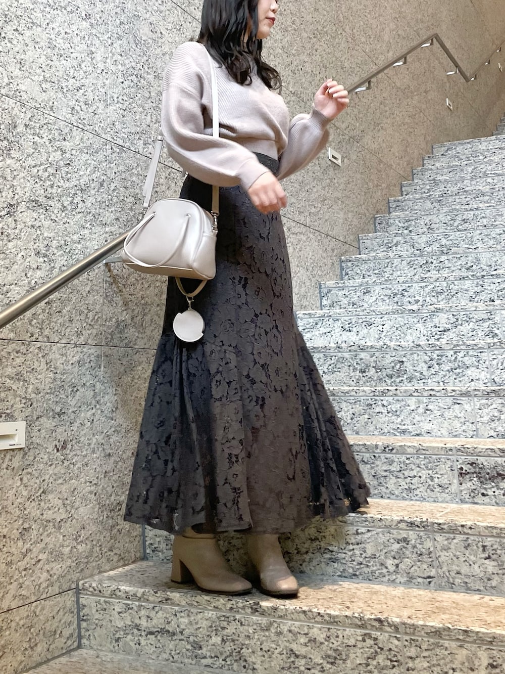 ベージュ系のブーツ、ブラウン系のニット/セーター、グレー系のスカートを着用したレディースの冬コーディネートの2枚目の写真