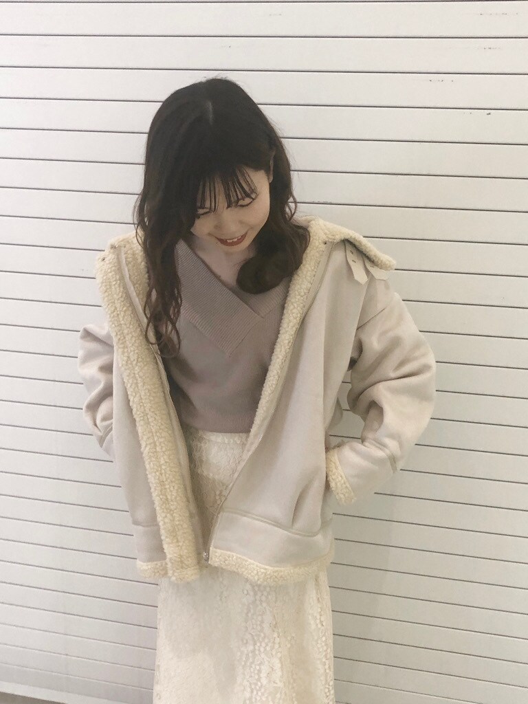 ブラウン系のブーツ、ホワイト系のスカート、ホワイト系のブルゾンを着用したレディースの冬コーディネートの3枚目の写真