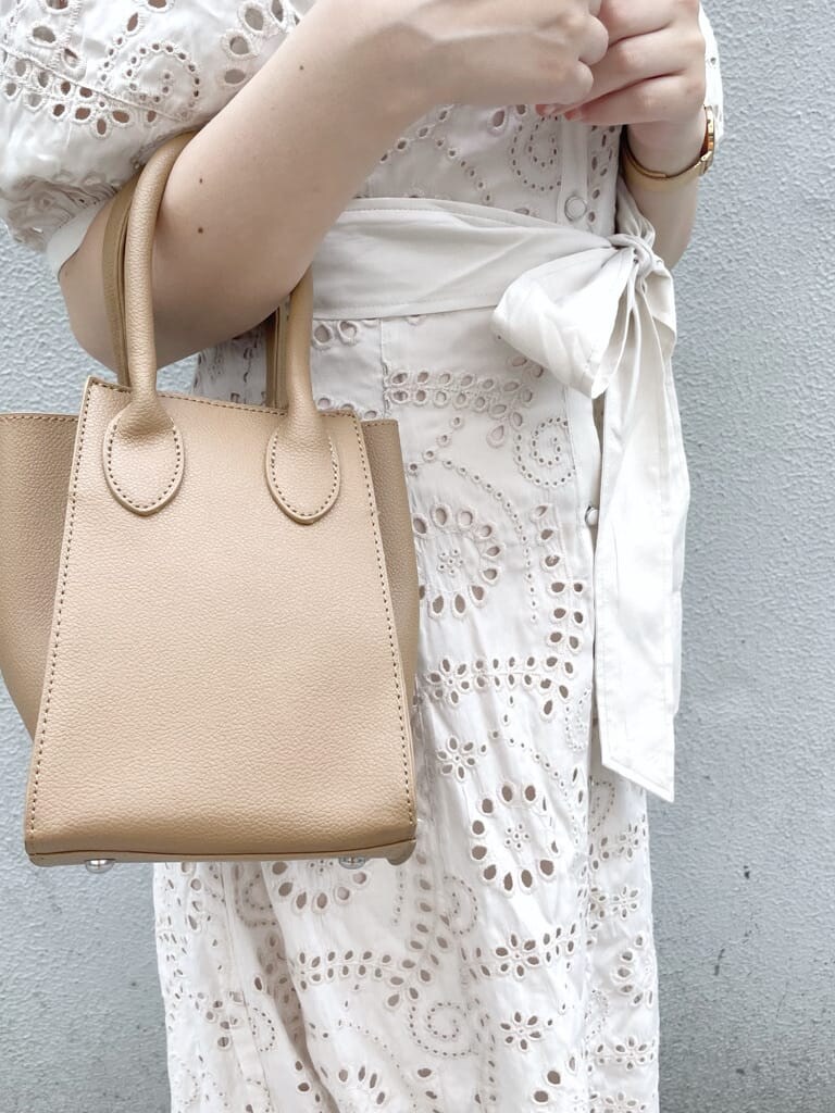 ホワイト系のワンピース、ベージュ系のハンドバッグ、ホワイト系のパンプスを着用したレディースの春コーディネートの8枚目の写真