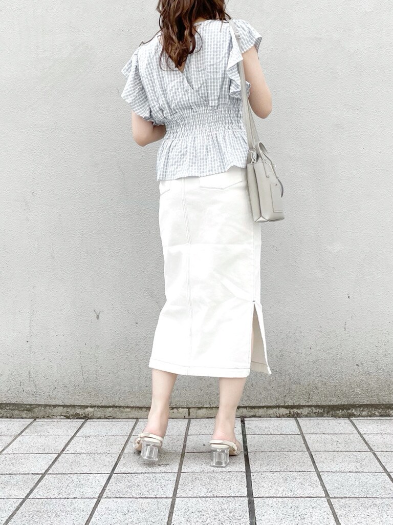 グレー系のハンドバッグ、ブルー系のシャツ/ブラウス、ホワイト系のスカートを着用したレディースの春コーディネートの4枚目の写真